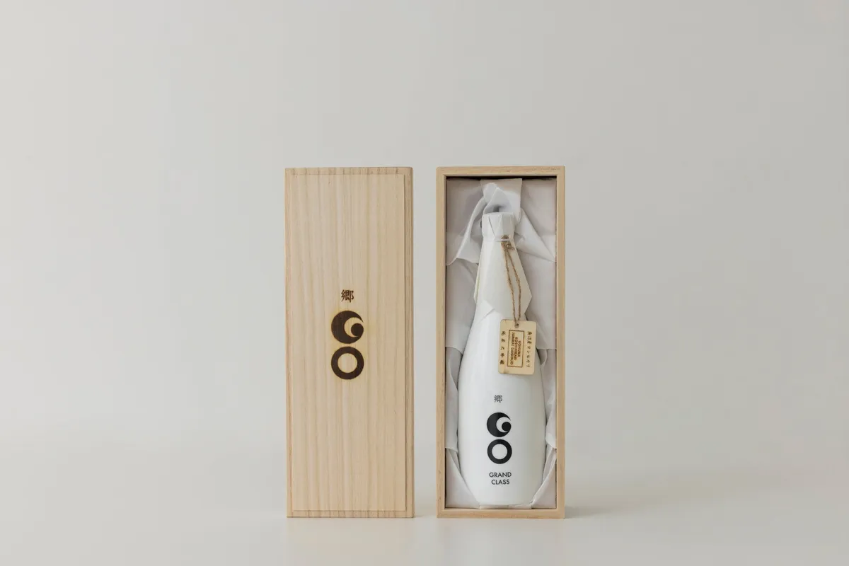 ขวด Junmai Daiginjo Uonuma Koshihikari ของ GO GRANDCLASS ในกล่องไม้พอลโลเนียสำหรับนำเสนอ